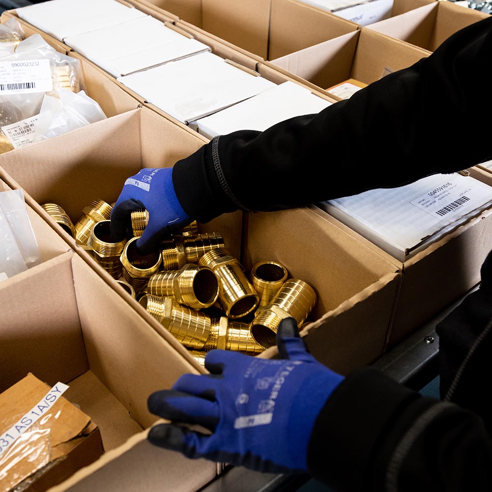 Lådor med olika produkter i som plockas. Bilden illustrerar hur man kan öka plockhastigheten på varor och på så sätt optimera lagret.